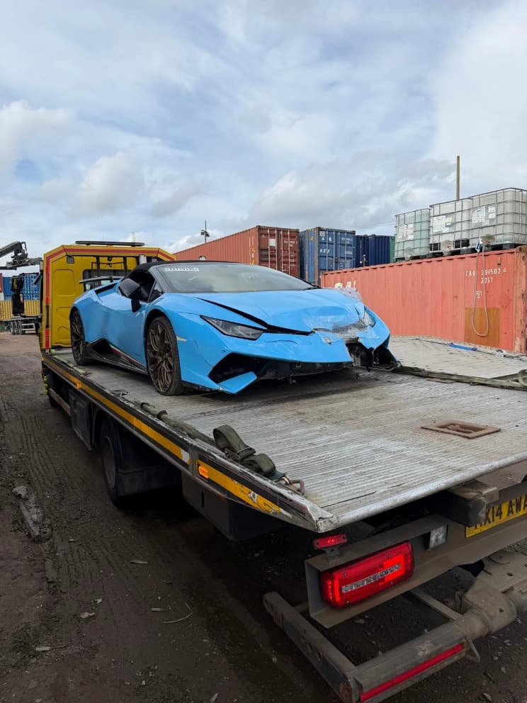 Crash-damaged Lamborghini Huracan loaded on a flatbed recovery truck
